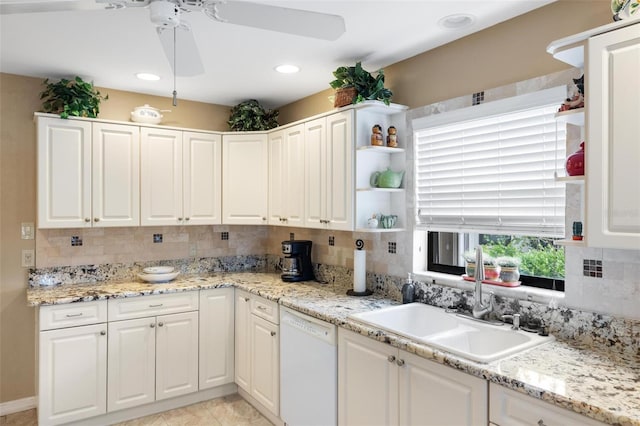 kitchen with a sink, tasteful backsplash, white cabinets, and white dishwasher