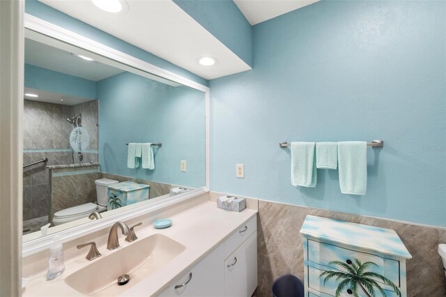 bathroom featuring tiled shower, recessed lighting, toilet, and vanity