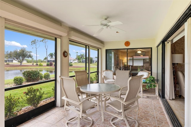 sunroom with a water view and ceiling fan