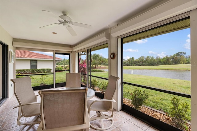 sunroom / solarium featuring a water view and ceiling fan