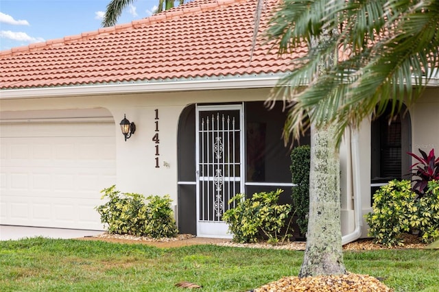 view of exterior entry with a garage and stucco siding