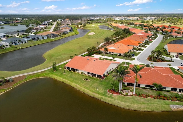 drone / aerial view with a residential view, a water view, and view of golf course