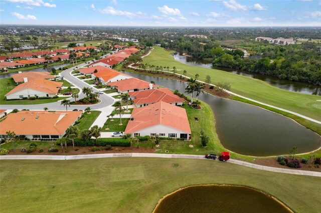 drone / aerial view featuring a residential view, a water view, and golf course view