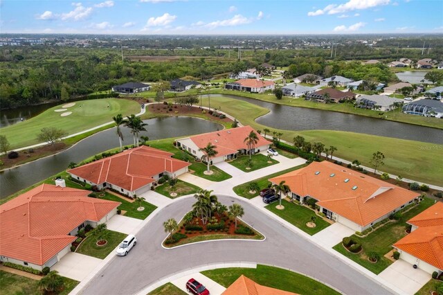 birds eye view of property with view of golf course, a water view, and a residential view