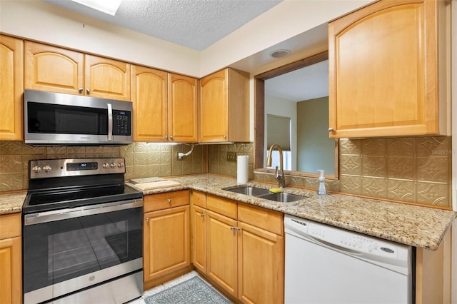 kitchen with stainless steel appliances, a sink, and decorative backsplash