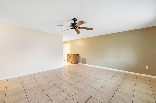 empty room with visible vents, ceiling fan, and baseboards