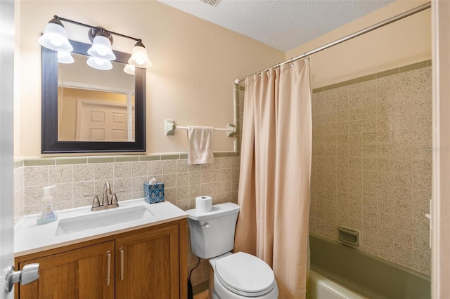 bathroom with a textured ceiling, toilet, shower / tub combo, vanity, and tile walls