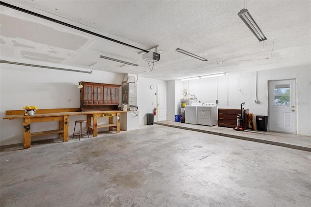 garage featuring separate washer and dryer, a workshop area, heating unit, and a garage door opener