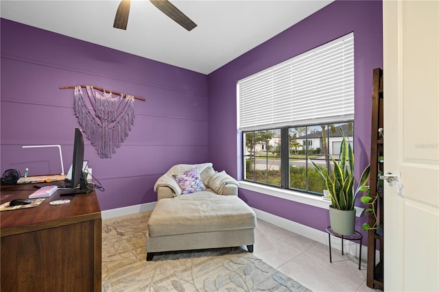 sitting room with ceiling fan, baseboards, and tile patterned floors