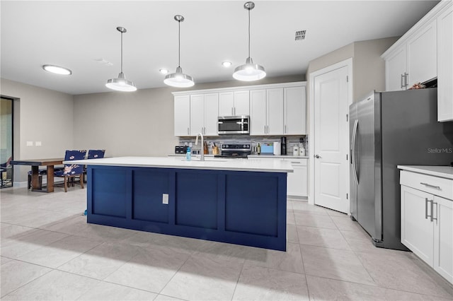 kitchen with a sink, visible vents, white cabinetry, light countertops, and appliances with stainless steel finishes