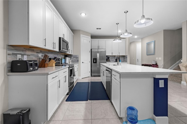 kitchen with stainless steel appliances, light countertops, a sink, and white cabinetry