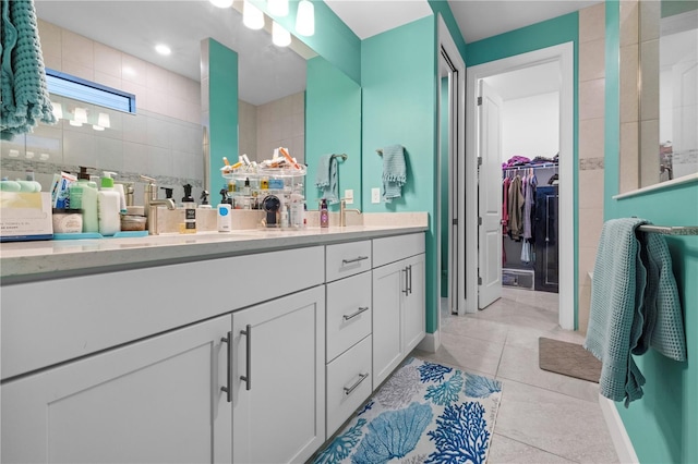 full bath featuring a walk in shower, a walk in closet, vanity, and tile patterned floors