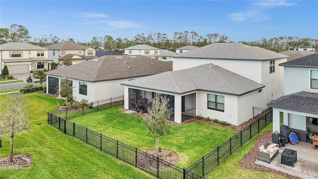 back of property featuring a yard, a shingled roof, a sunroom, a residential view, and a fenced backyard