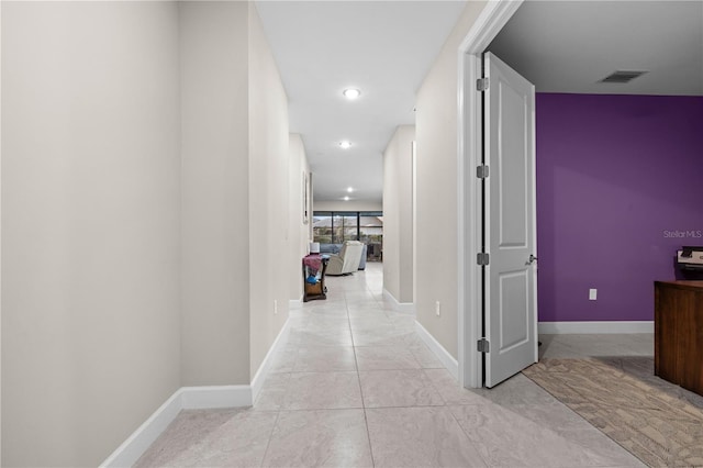 hallway with baseboards, visible vents, and recessed lighting