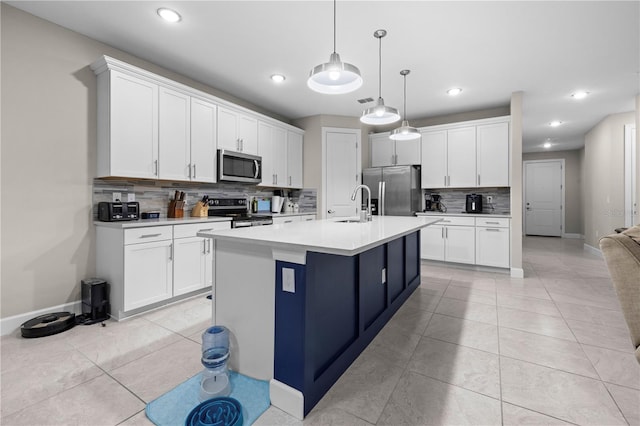 kitchen with stainless steel appliances, light tile patterned flooring, and white cabinetry