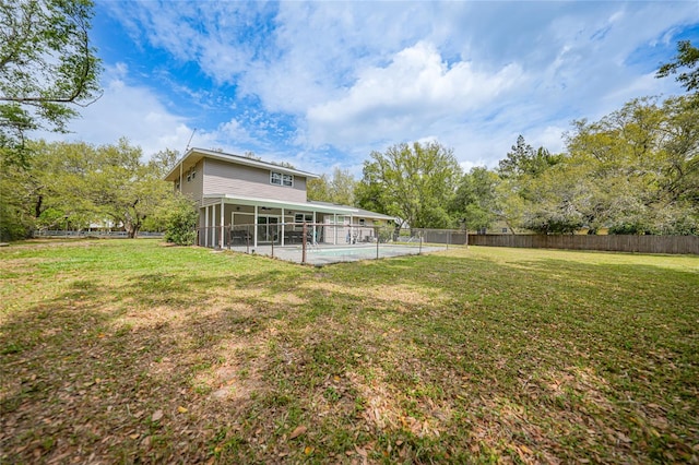 view of yard featuring a sunroom, fence, and a fenced in pool