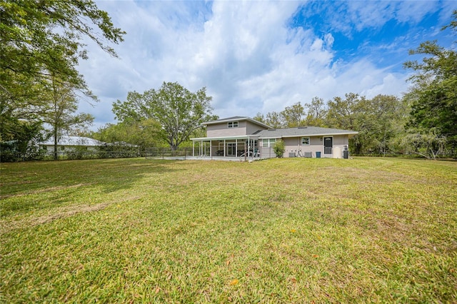 view of yard featuring fence and a sunroom