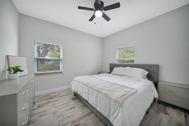 bedroom featuring baseboards, ceiling fan, and light wood-style floors