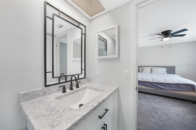bathroom featuring a textured ceiling, visible vents, a ceiling fan, and vanity