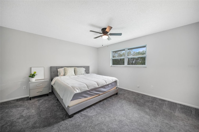 bedroom with a ceiling fan, baseboards, dark carpet, and a textured ceiling