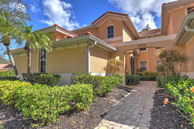 exterior space with a tiled roof and stucco siding