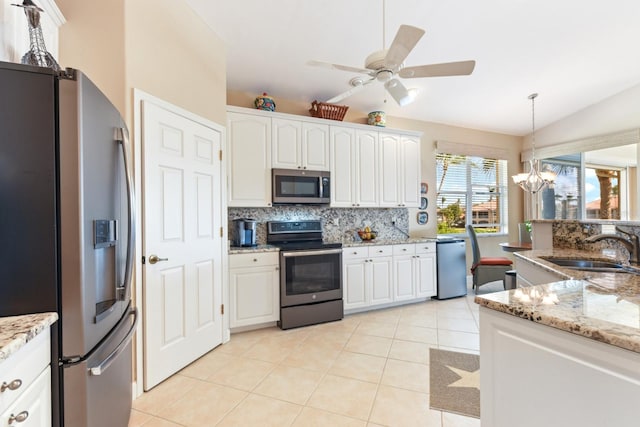 kitchen featuring backsplash, vaulted ceiling, appliances with stainless steel finishes, light tile patterned flooring, and a sink