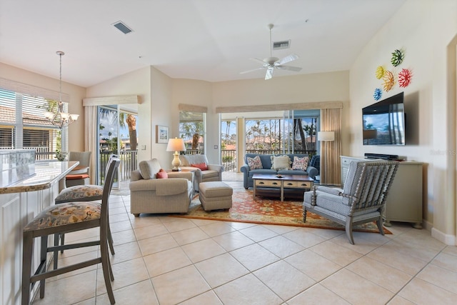 living room featuring vaulted ceiling, light tile patterned floors, ceiling fan with notable chandelier, and visible vents