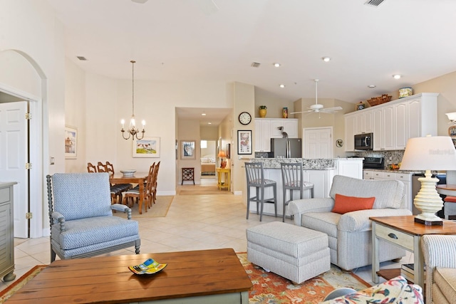 living area with light tile patterned flooring, visible vents, ceiling fan with notable chandelier, and recessed lighting