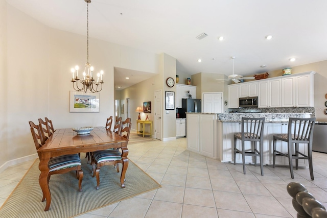 dining area with vaulted ceiling, light tile patterned floors, ceiling fan with notable chandelier, and visible vents