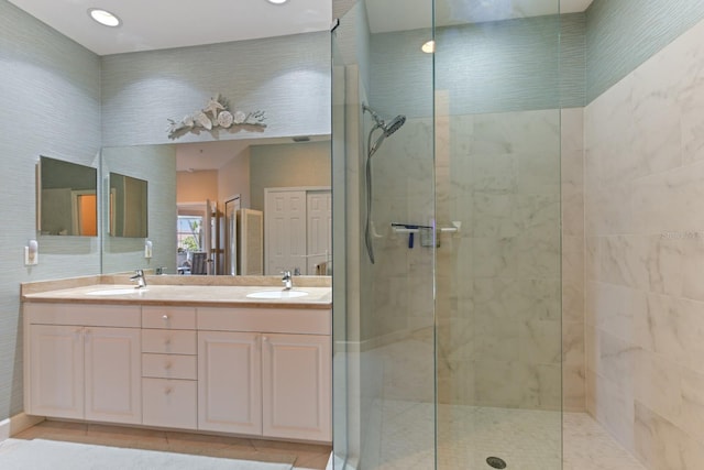 full bath featuring a sink, walk in shower, double vanity, and tile patterned flooring