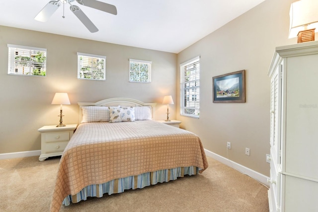 bedroom with light colored carpet, ceiling fan, baseboards, and multiple windows