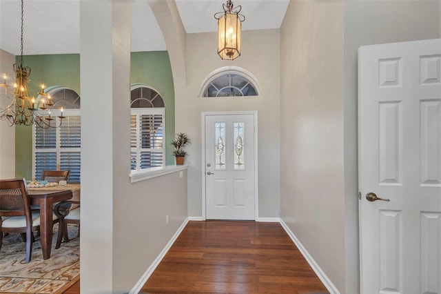 entrance foyer with baseboards, a chandelier, and dark wood-style flooring