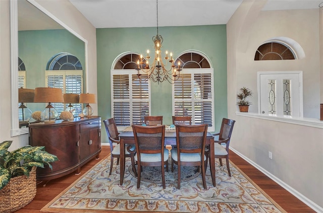 dining room with a healthy amount of sunlight, an inviting chandelier, baseboards, and wood finished floors