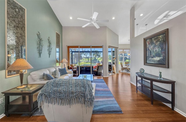 living area with ceiling fan, recessed lighting, a high ceiling, wood finished floors, and baseboards