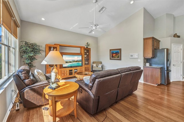 living room featuring baseboards, visible vents, a ceiling fan, wood finished floors, and high vaulted ceiling