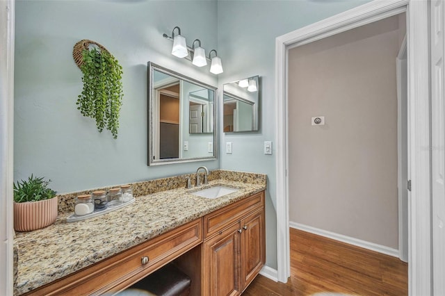 bathroom featuring wood finished floors, vanity, and baseboards