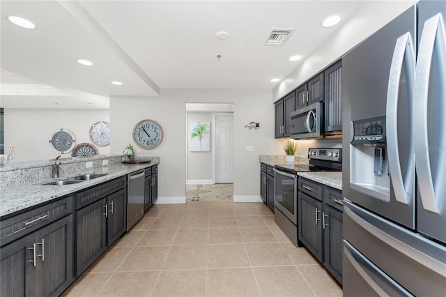 kitchen featuring visible vents, light stone countertops, recessed lighting, stainless steel appliances, and a sink