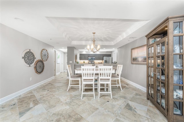 unfurnished dining area with a chandelier, recessed lighting, a raised ceiling, and baseboards