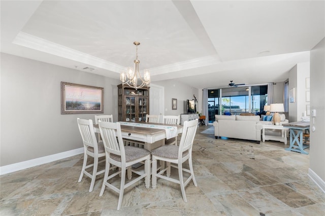 dining room featuring a tray ceiling, baseboards, and a chandelier