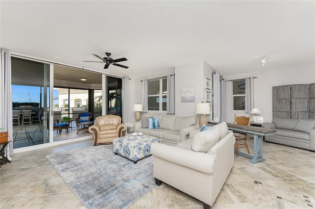 living area featuring floor to ceiling windows and ceiling fan