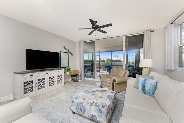 living room featuring baseboards, ceiling fan, and floor to ceiling windows