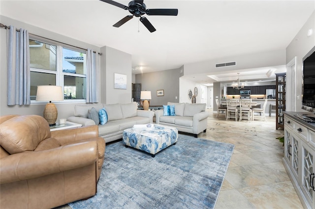 living area featuring visible vents and ceiling fan with notable chandelier