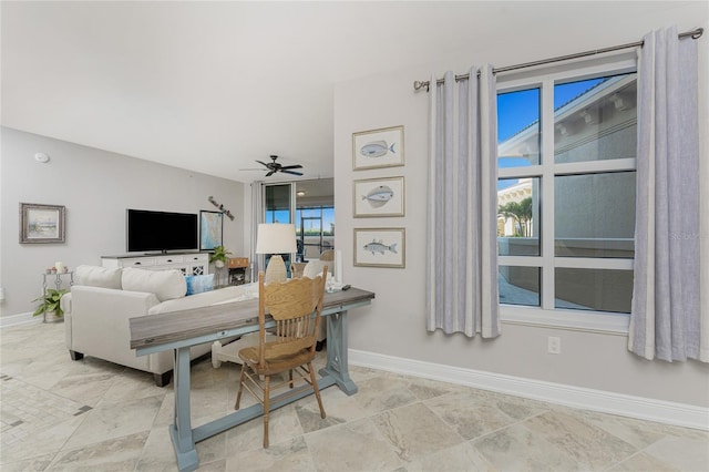 living room featuring a ceiling fan and baseboards