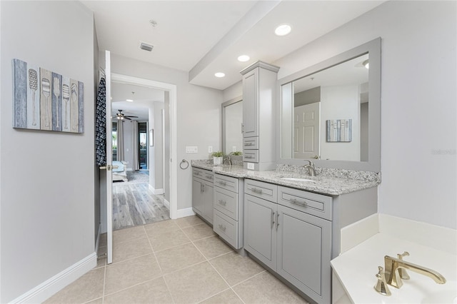 ensuite bathroom featuring vanity, baseboards, recessed lighting, tile patterned floors, and a bath