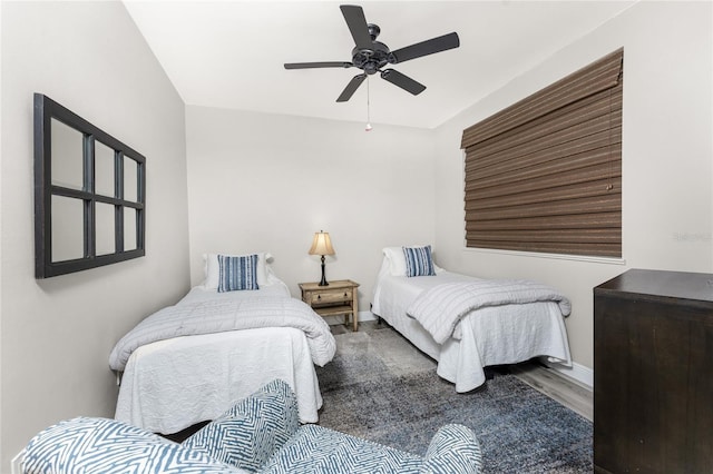 bedroom featuring a ceiling fan, baseboards, and wood finished floors