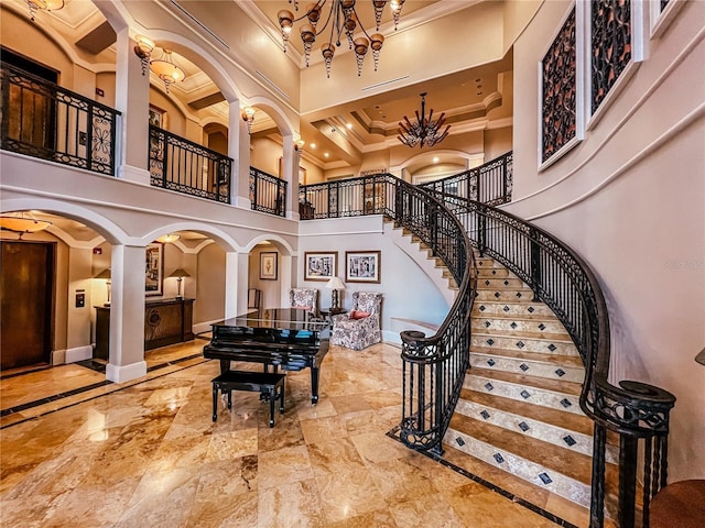 staircase with baseboards, decorative columns, arched walkways, a towering ceiling, and crown molding