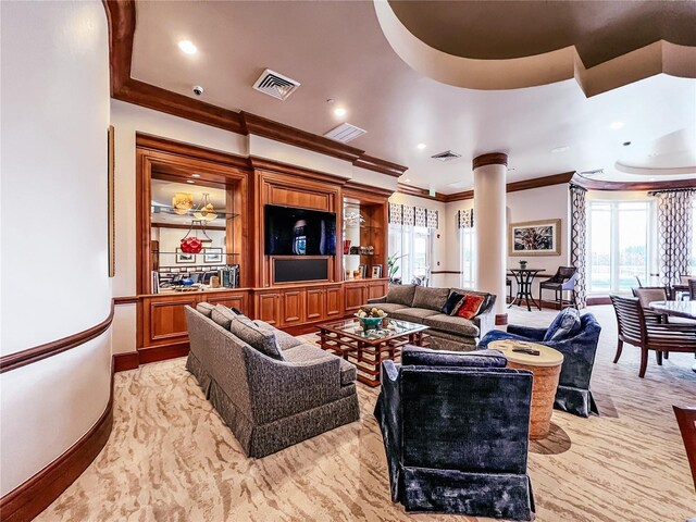 living room featuring a healthy amount of sunlight, visible vents, ornate columns, and ornamental molding