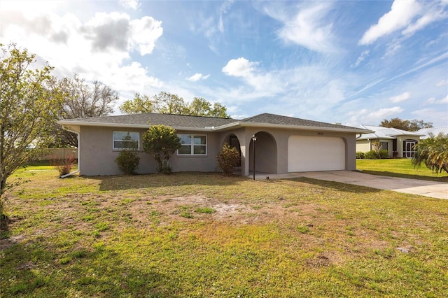 ranch-style house with a garage, a front yard, concrete driveway, and stucco siding