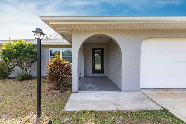 doorway to property featuring stucco siding