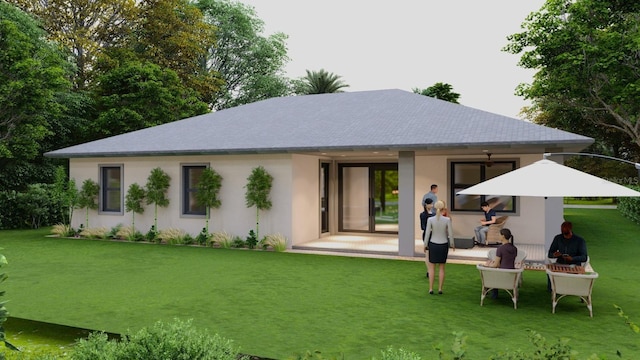 back of property with stucco siding, a shingled roof, a patio, and a yard